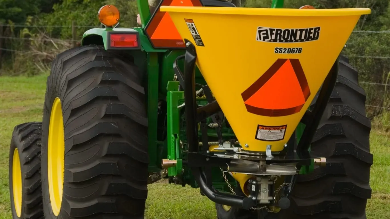 Field image of SS2067B broadcast spreader attached to rear of Tractor