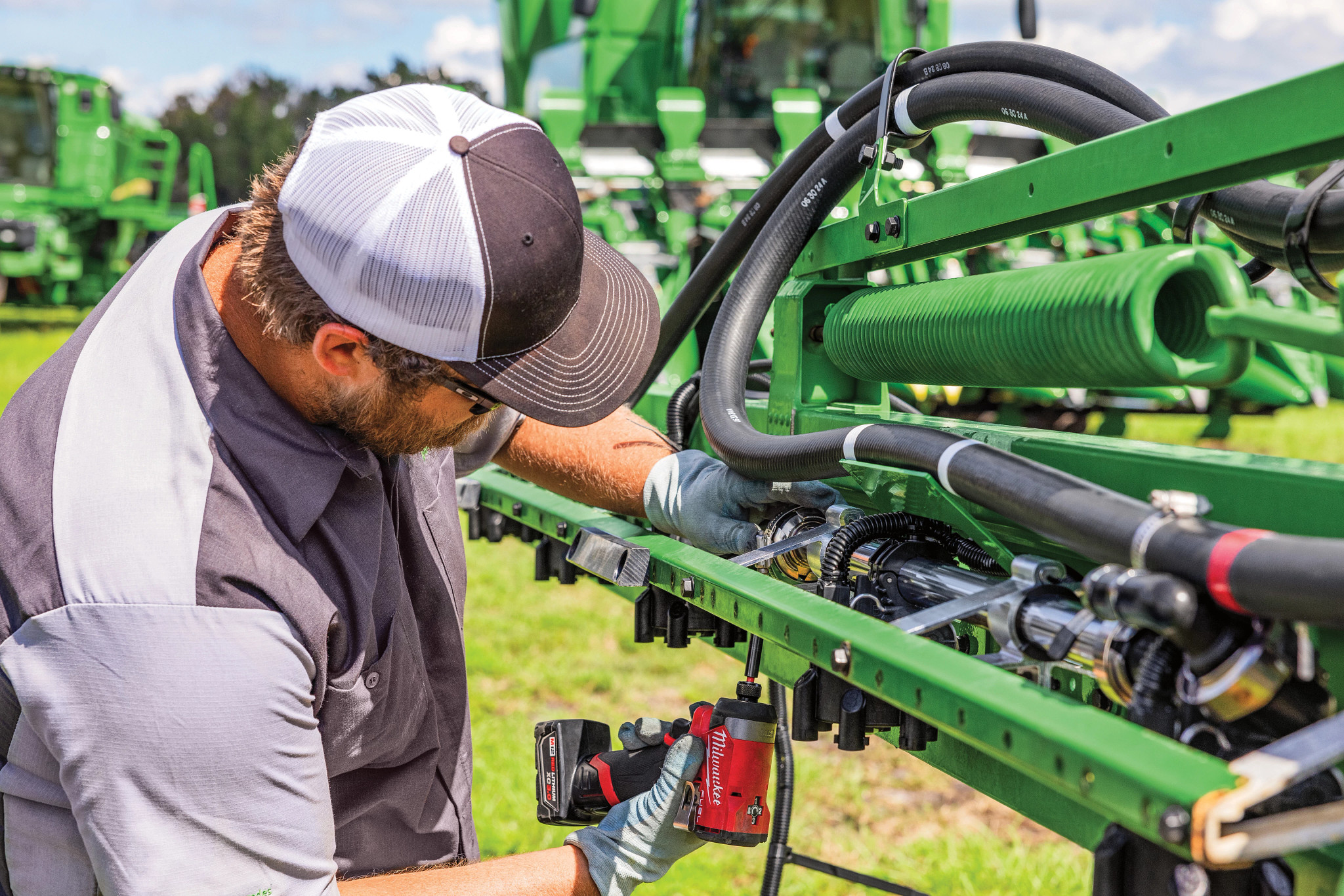 Technician working on a John Deere sprayer solution system