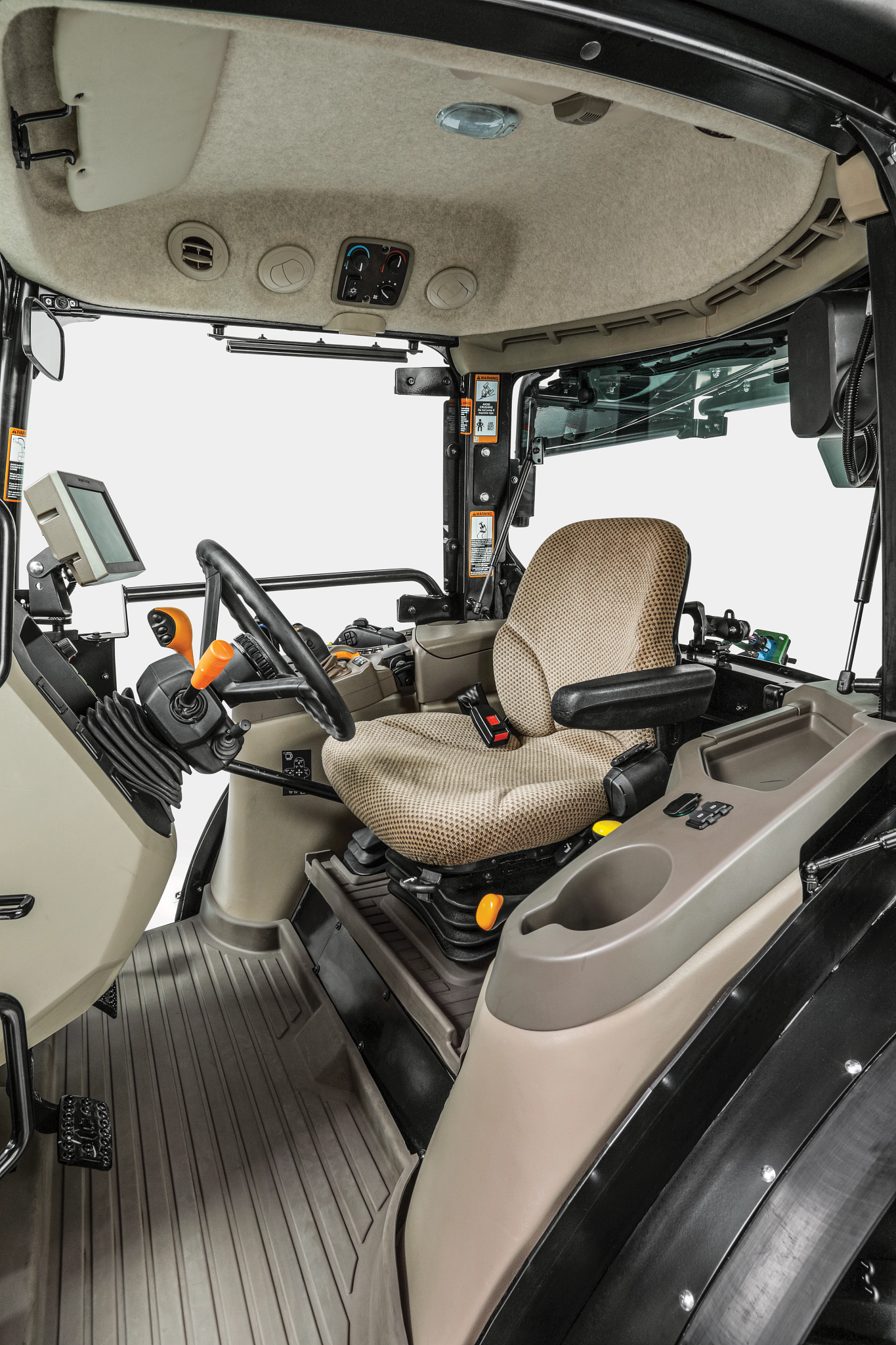 Side angled view of the inside of the tan and black cab of a 5130ML high-value crop tractor in studio