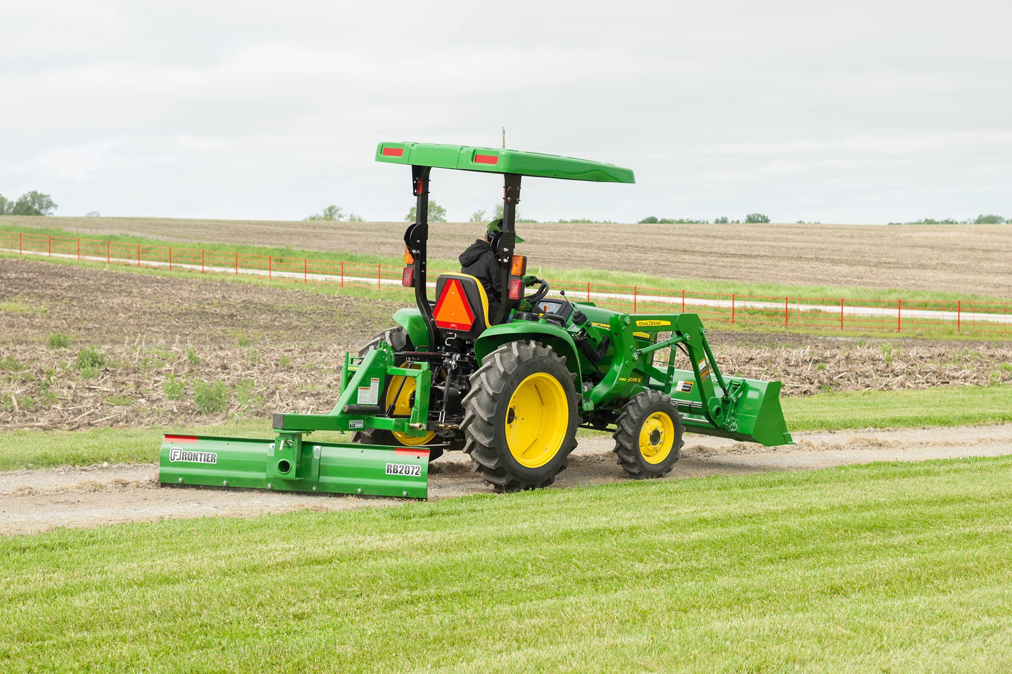 3038E Tractor with rear blade and front loader on dirt drive