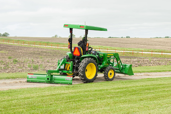 3038E Tractor with rear blade and front loader on dirt drive