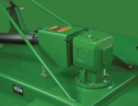 Close-up of a green mechanical gearbox and driveline assembly on a John Deere rotary cutter