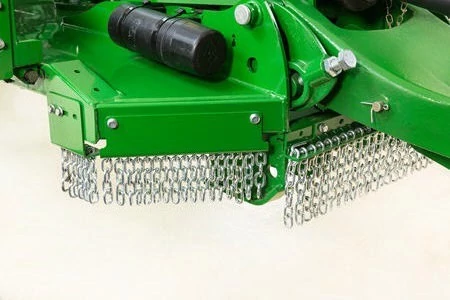 Close-up of a green flail mower showing the rear discharge area with rows of hanging metal chains beneath the cutting housing, designed to control debris.