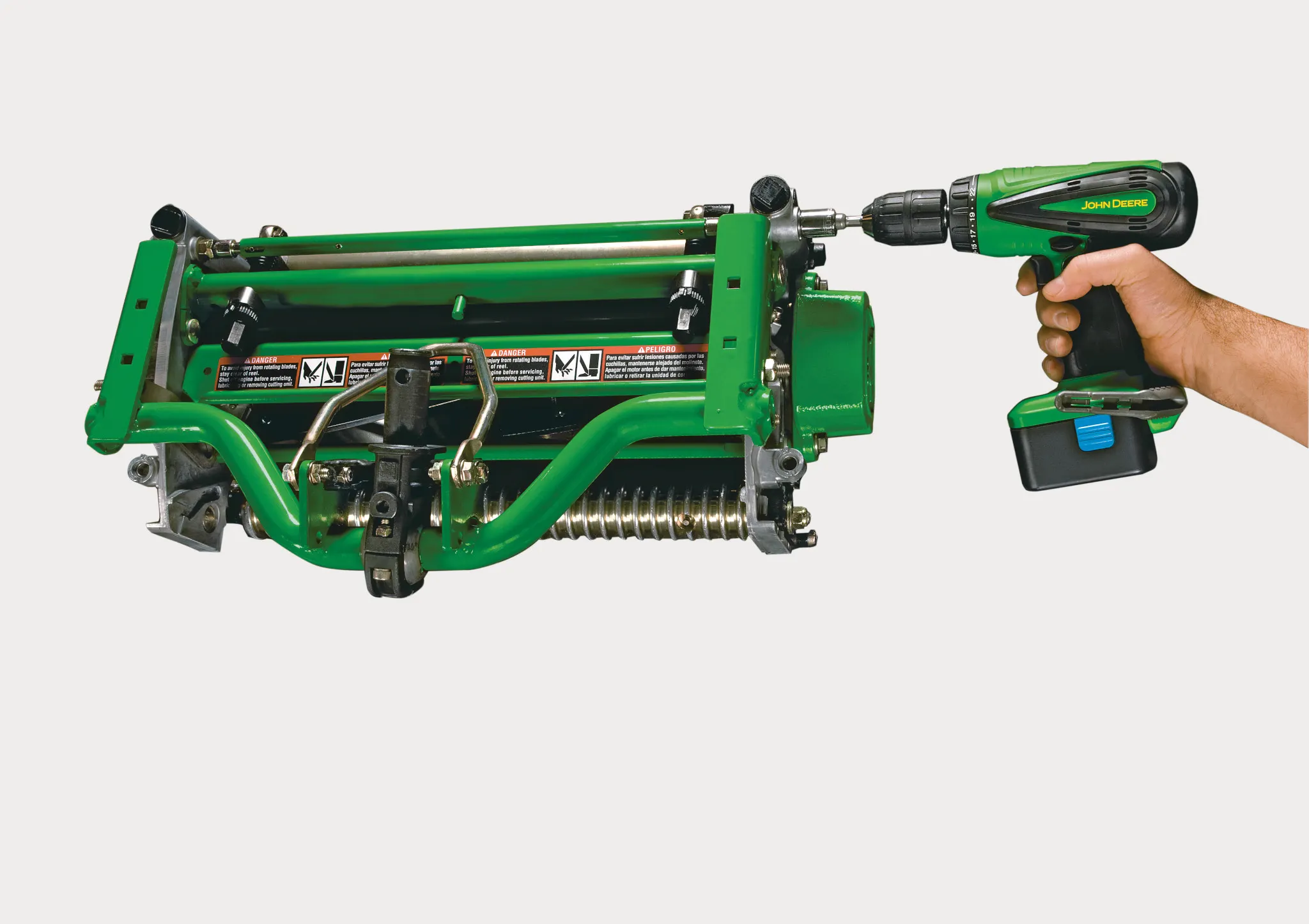 Studio close-up of hand operating drill on Walk Greens Mower