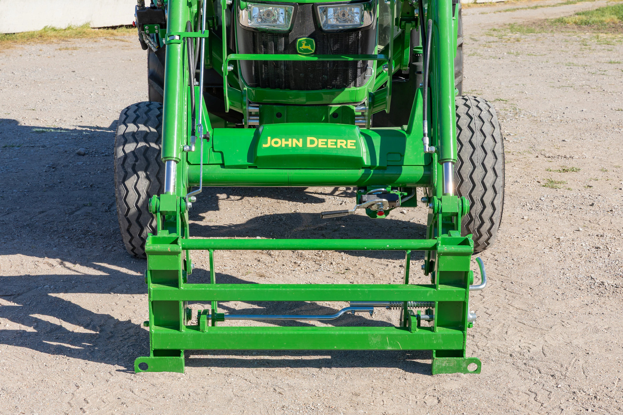Front view of a DA21G Quick-Attach Carrier Adapter on a 5075E Tractor sitting in a dirt lot