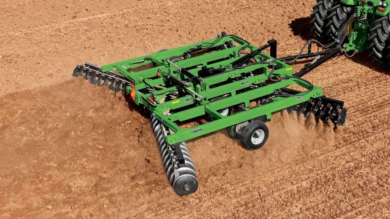 TM51 Series Tandem Disk Harrow pulled through a large dirt field by a tractor