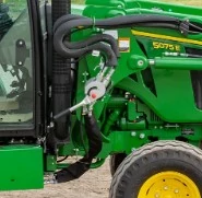 Side view of the hoses, couplers, and bracket at the connection point of a 500M loader to a 5075E tractor