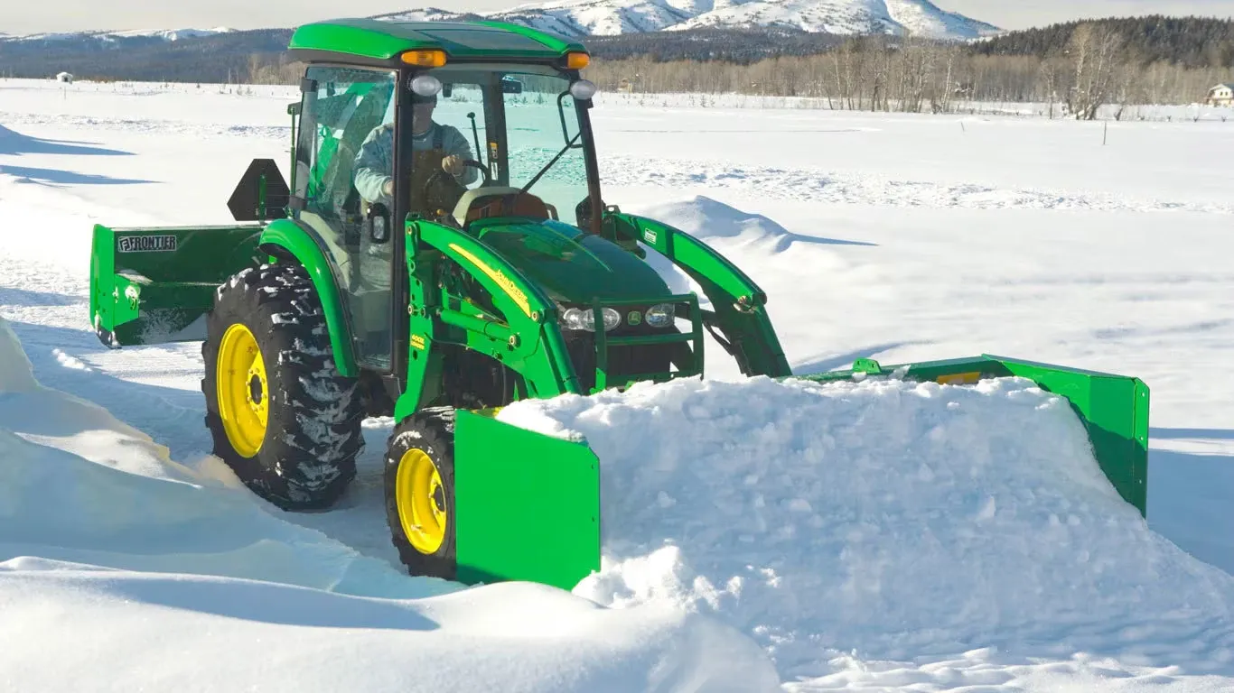 AS11E Snow Push clearing snow on a path next to an open field