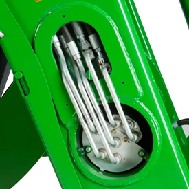 Studio close-up of a loader's open oil line panel on a green metal piece