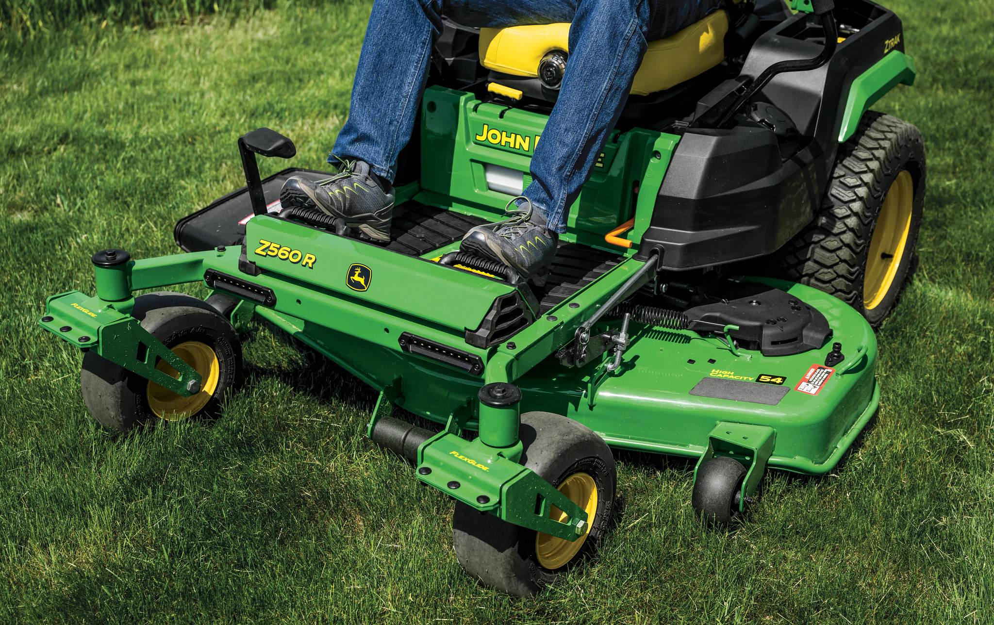 Close-up front-left-facing shot of a Z560R zero-turn mower deck and foot rest over grass.