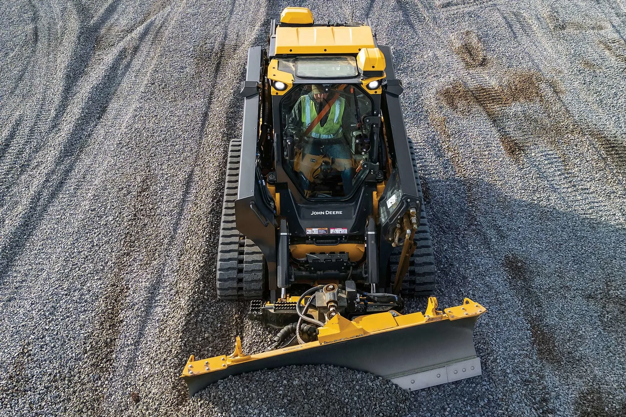 Top view of a 335 P-Tier compact track loader pushing gravel