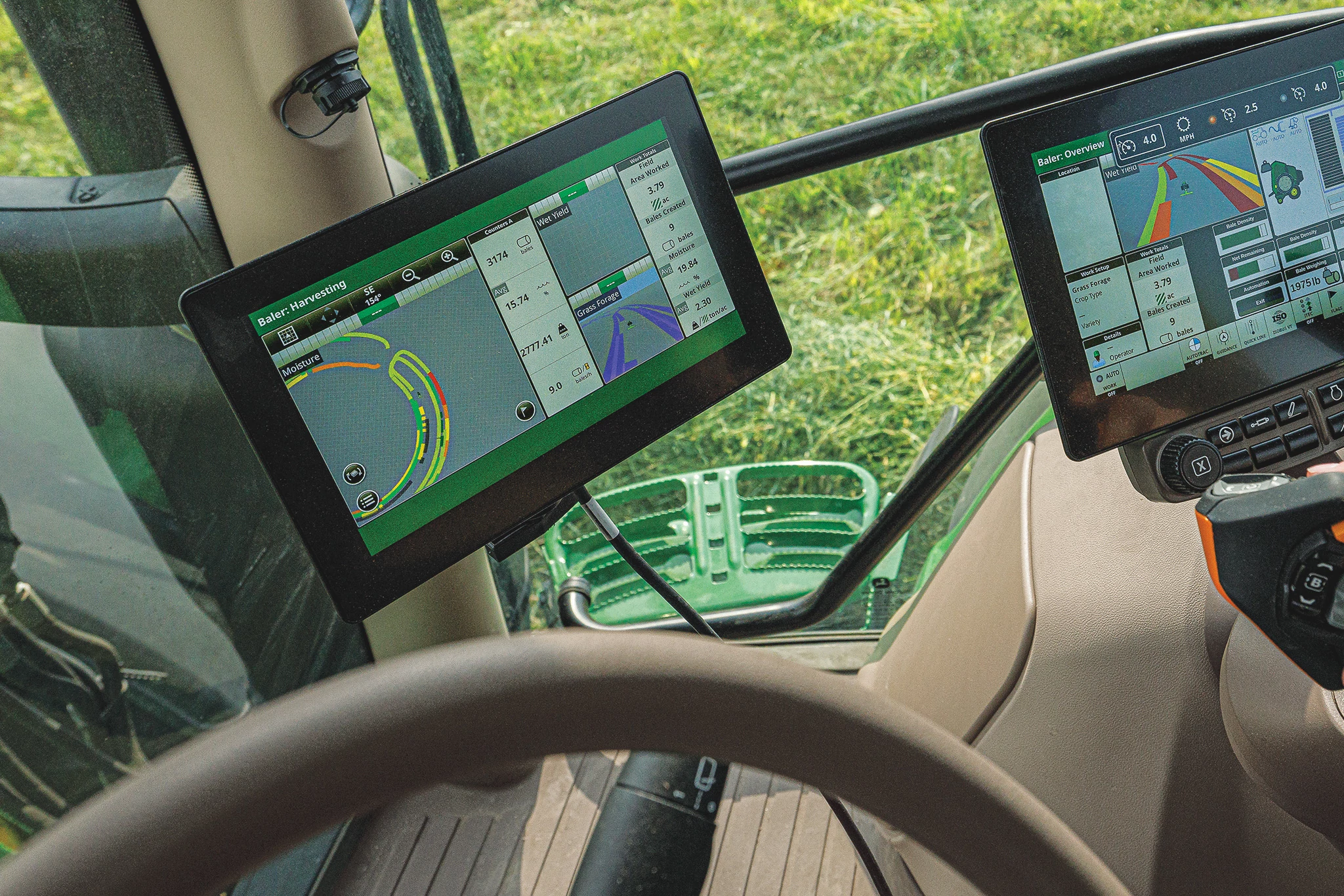 Interior of a John Deere tractor cab showing steering wheel, CommandPRO joystick, and multiple touchscreen displays with guidance and machine data, while operating over a grassy field.
