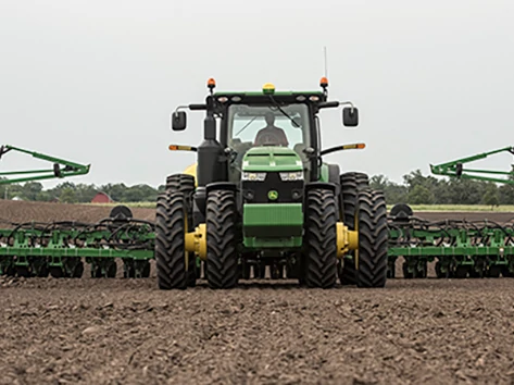 Tractor pulls a planter through field