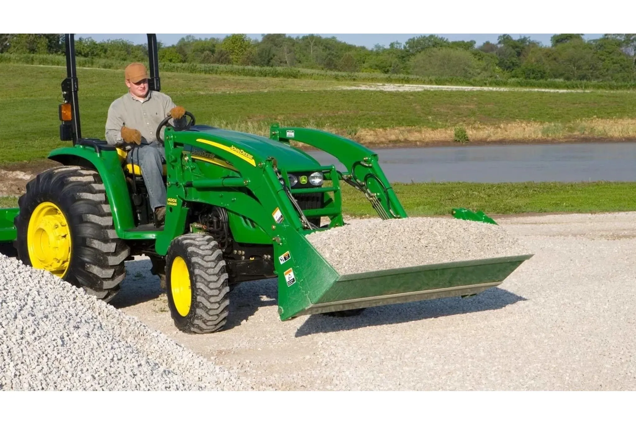 Farmer operating a tractor with an AY11 Loader Bucket attachment