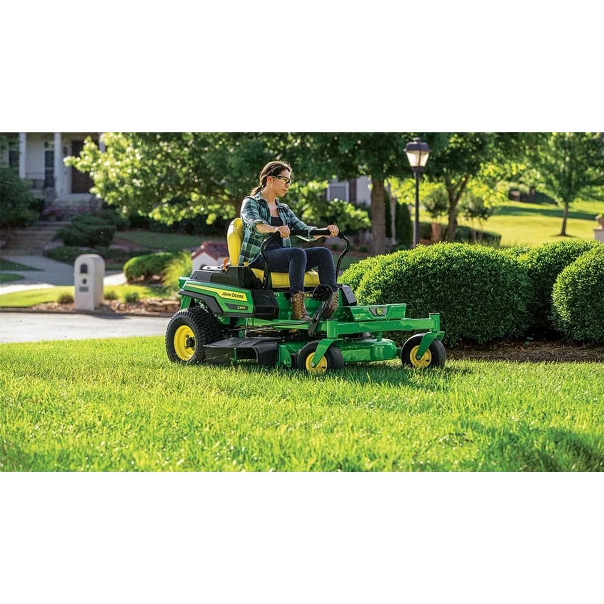 Homeowner mowing a yard with a John Deere Z315E ZTrak mower — Koenig Equipment