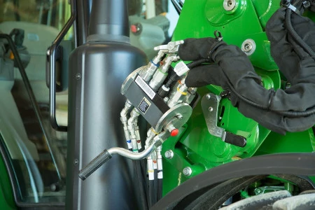 Front right close-up of the single-point hydraulic connection area on a 600R loader