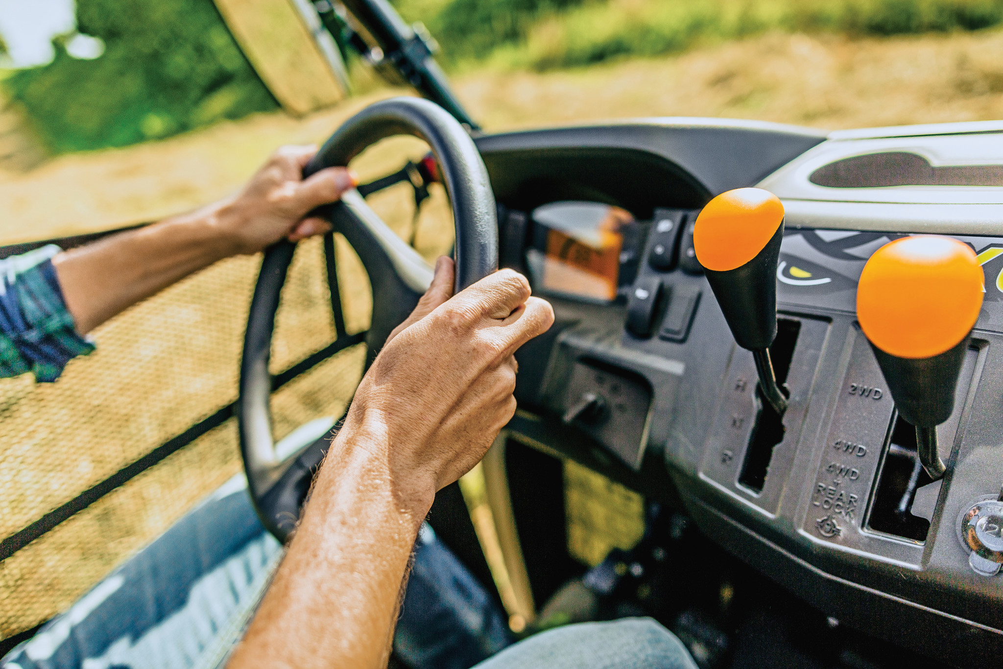 Side right view of the dash and steering wheel of an XUV560E Mid-Size Crossover Utility Vehicle, two hands steering