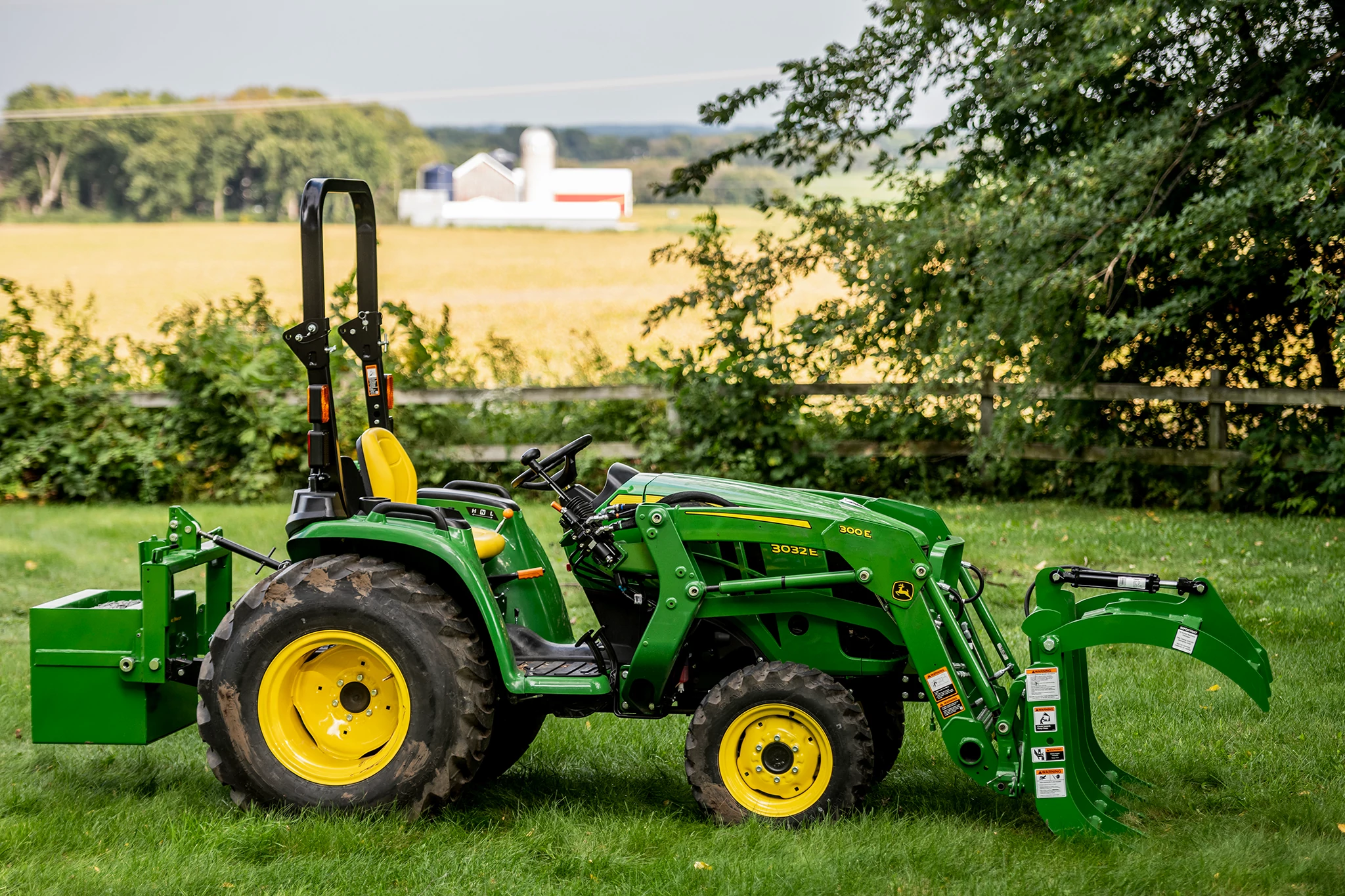 Utility Tractor with Root Grapple in grassy area