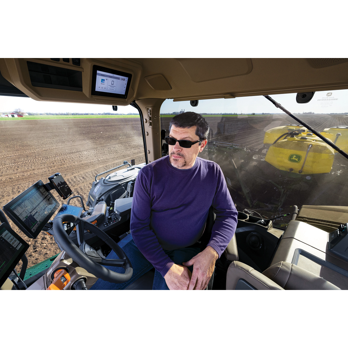 Operator using a John Deere in-cab precision display while running a planter - Koenig Equipment