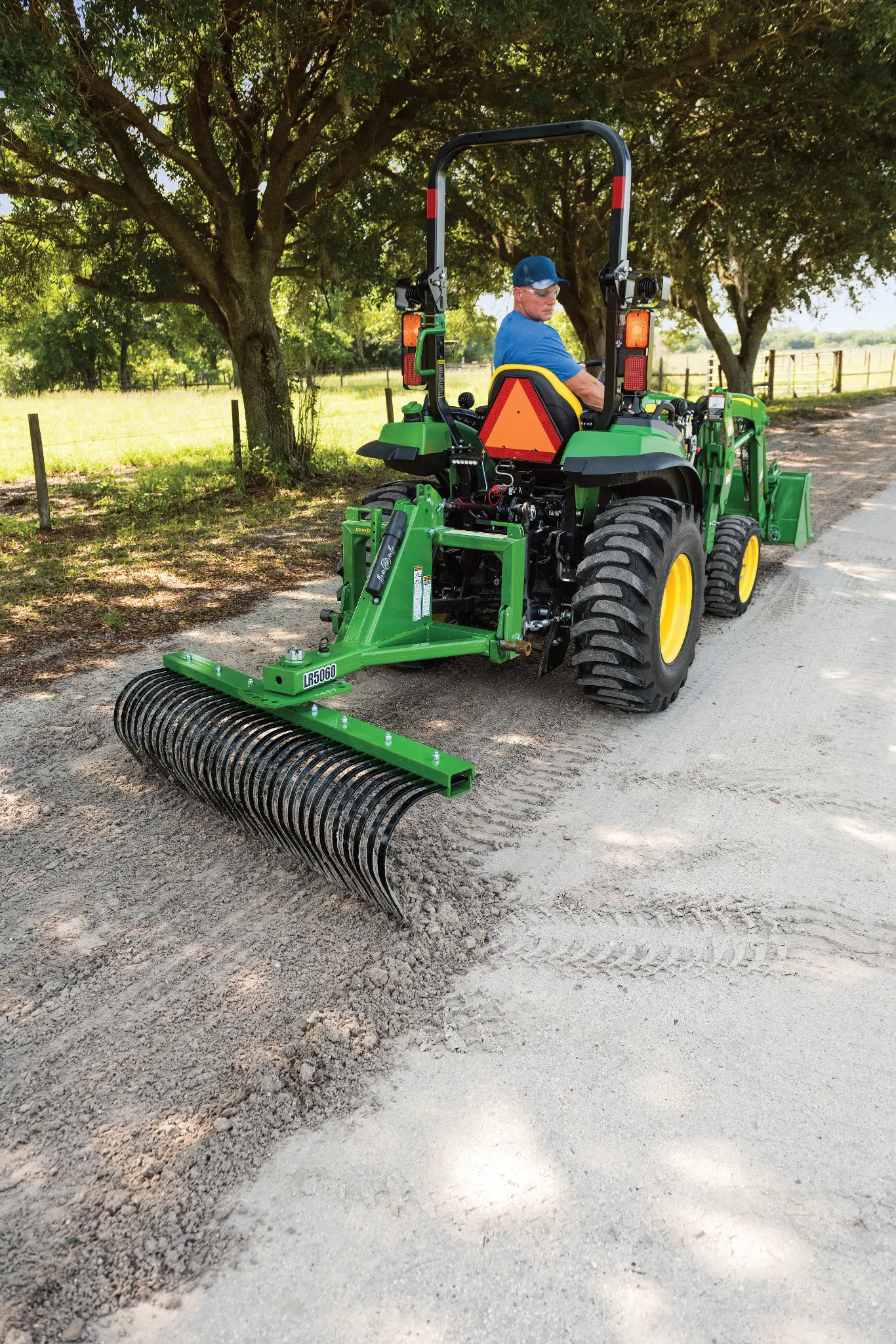 2032R Tractor raking dirt on a driveway using a LR5060 Landscape Rake
