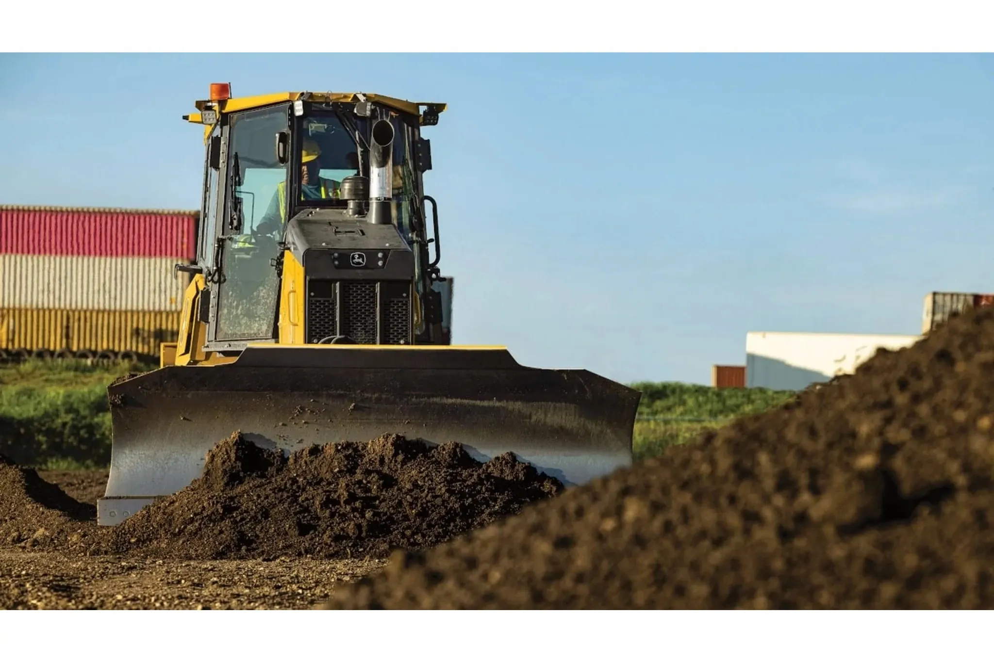 Front view of a 550P Dozer pushing dirt into a stockpile