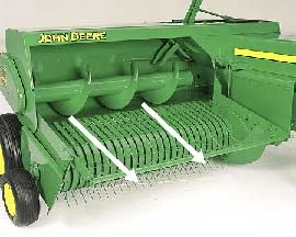 Front right studio view of a green, wheeled hay compressor from a small square baler with two white arrows point outward from the auger