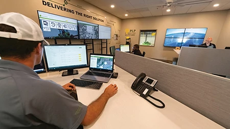 Man at a desk in an office looking at John Deere data on a computer