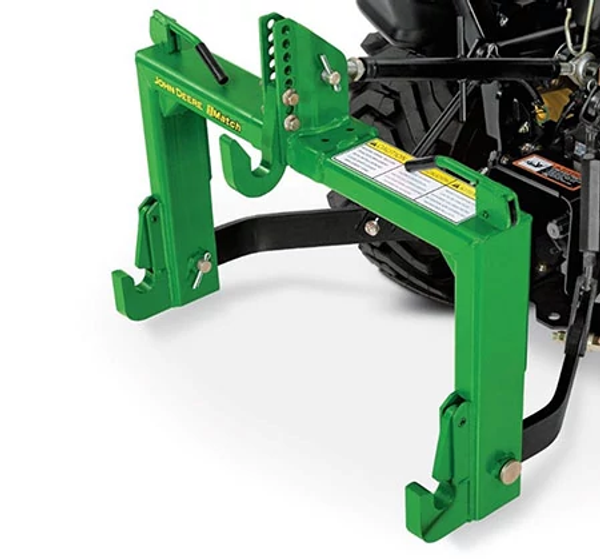 Green three-point hitch attachment mounted at the rear of a compact tractor, showing adjustable mounting hooks and hardware