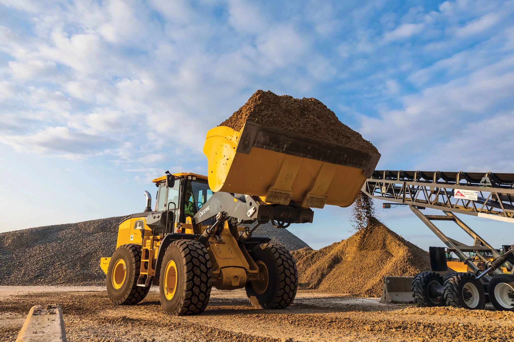 644 P-Tier wheel loader with a raised bucket full of gravel or dirt, parked on a dry, dusty construction site.