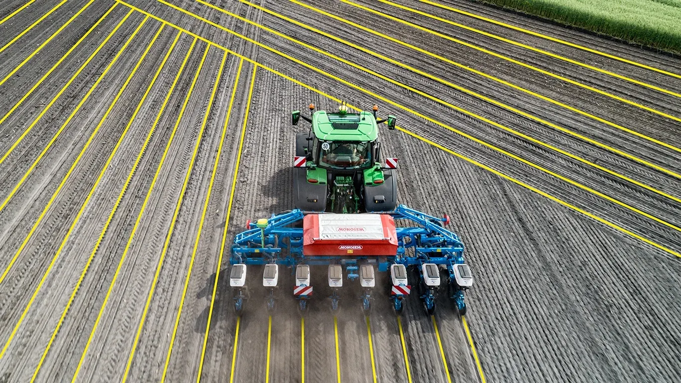 Digital projection of AutoPath lines surround a tractor pulling an implement through a field