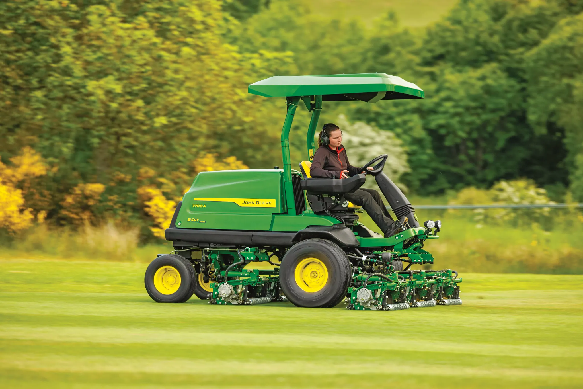 Woman operates a 7700A E-Cut fairway mower in the field