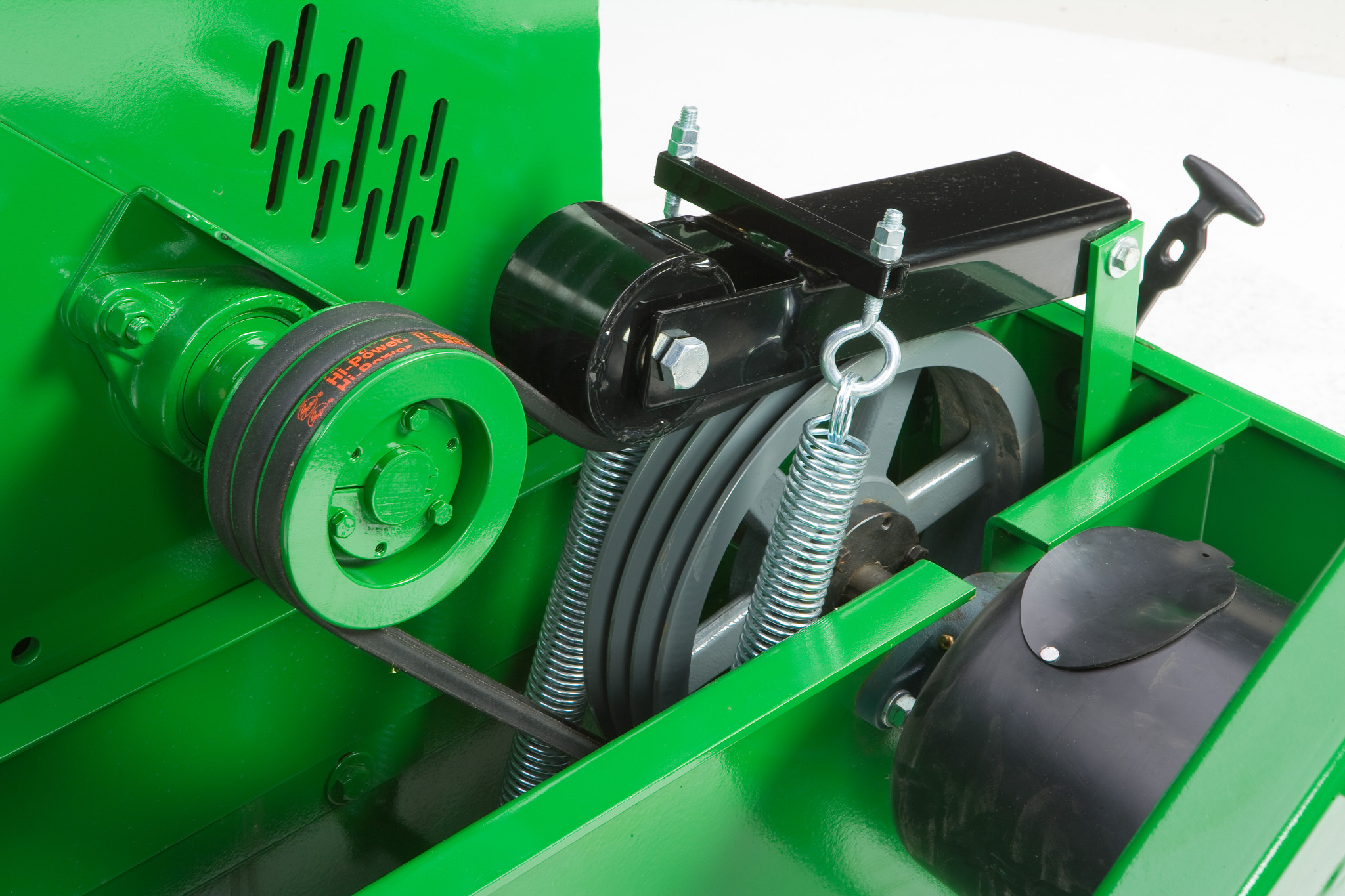 Close-up of wood chipper showing a belt‑driven pulley system with springs, tensioners, and protective guards