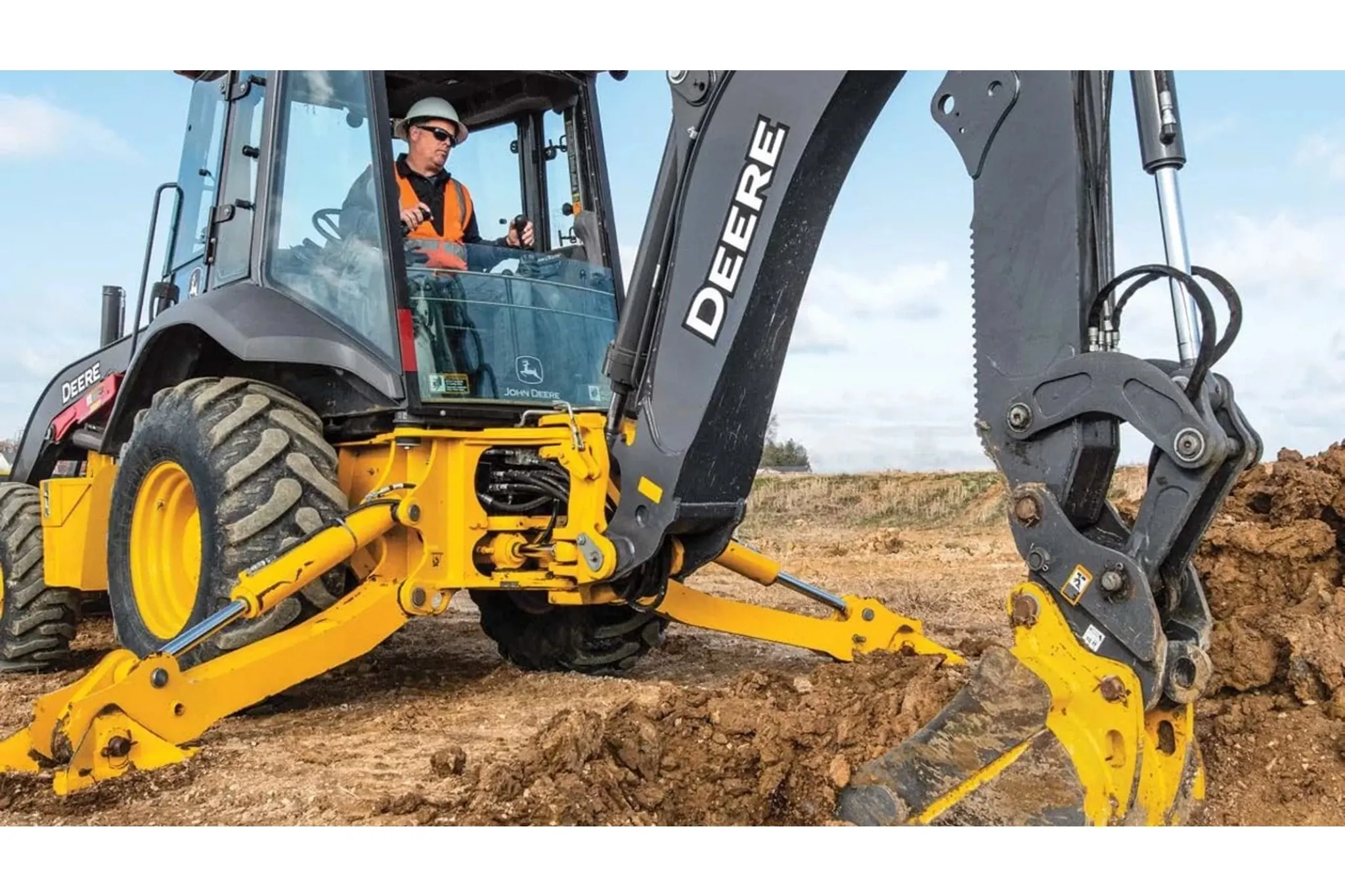 310 P-Tier Backhoe Loader with a close up of a operator digging a hole at a construction site