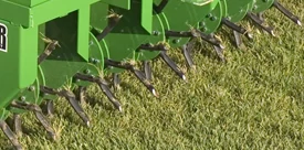 Close-up of a CA20 core aerator's eight spoons per hub digging into grass