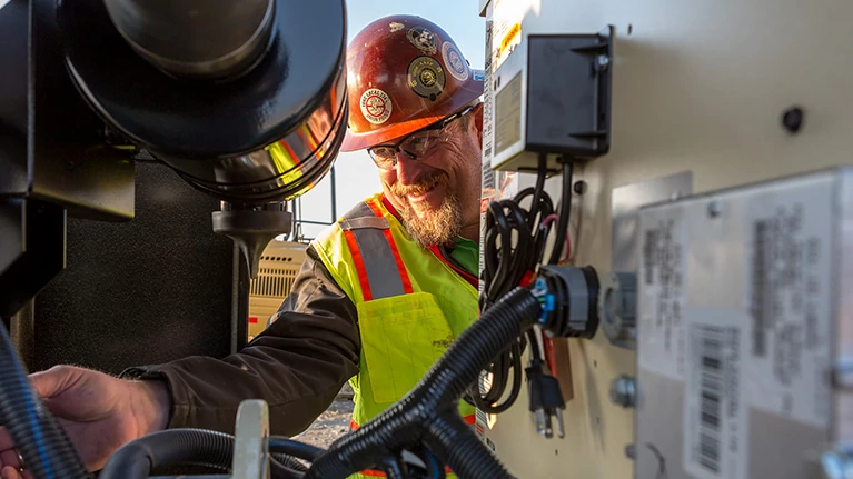 Worker checking on generator drive engine, JD14X