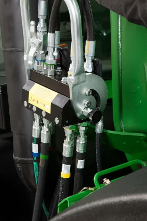 Close-up side view of a 700M loader's single-point hydraulic connection