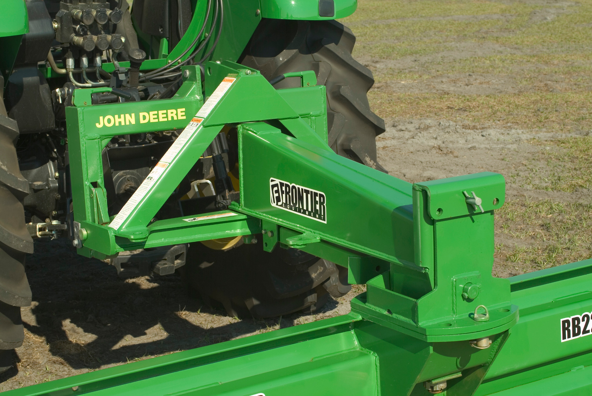 Rear view of adjustable turntable on Frontier rear blade hooked up to a tractor in a field