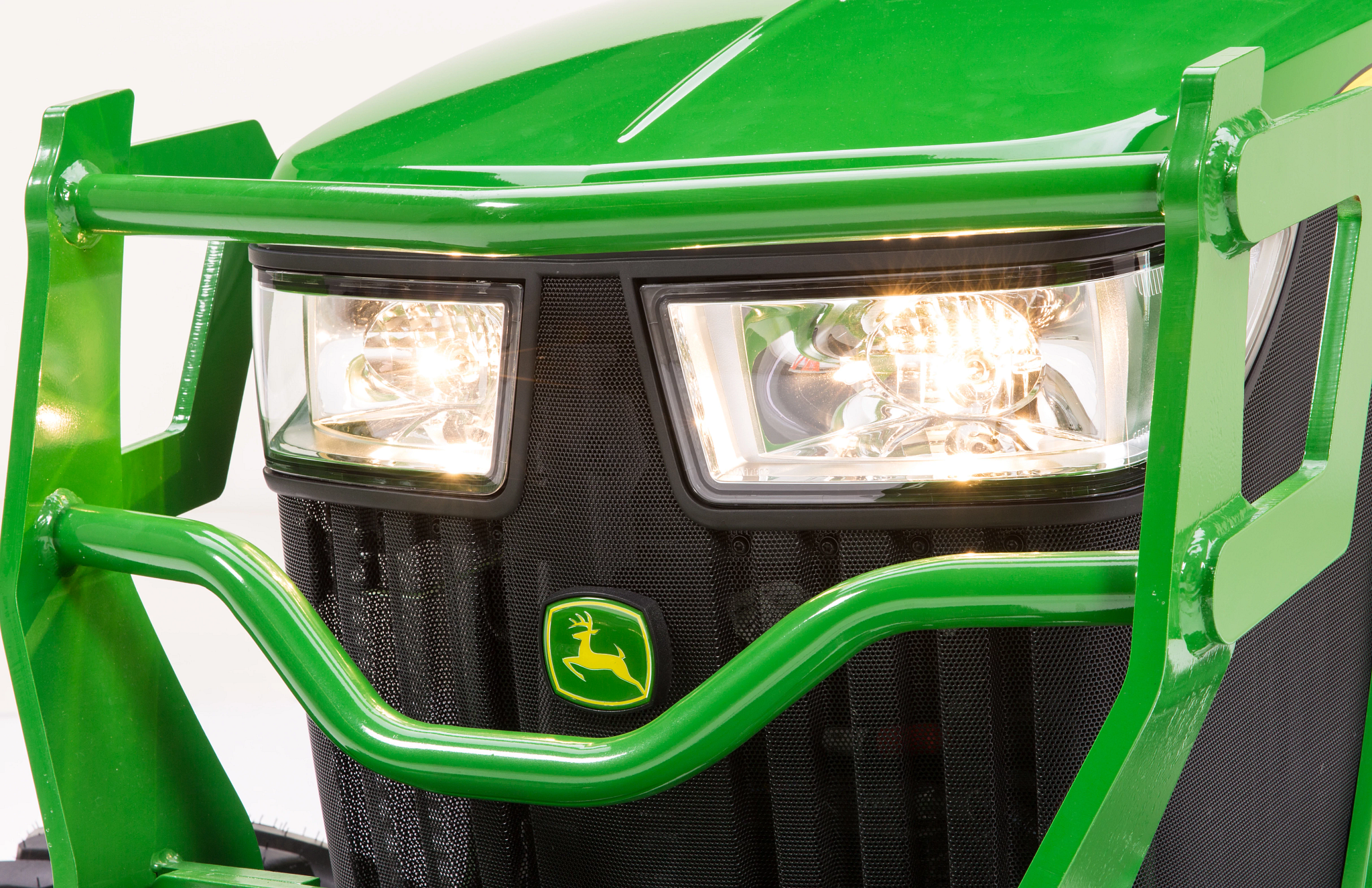 Studio front left view of the headlights and front protective bars of a 4052M Compact Utility Tractor