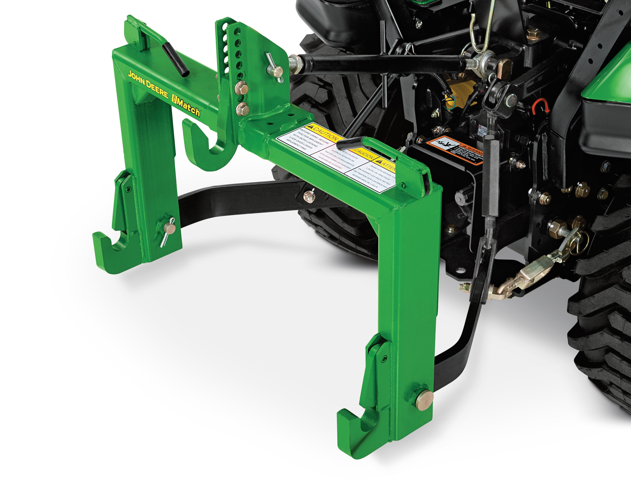 Close-up of a green rear mounting frame attached to a compact tractor, showing the steel support arms, mounting hooks, and hydraulic connections