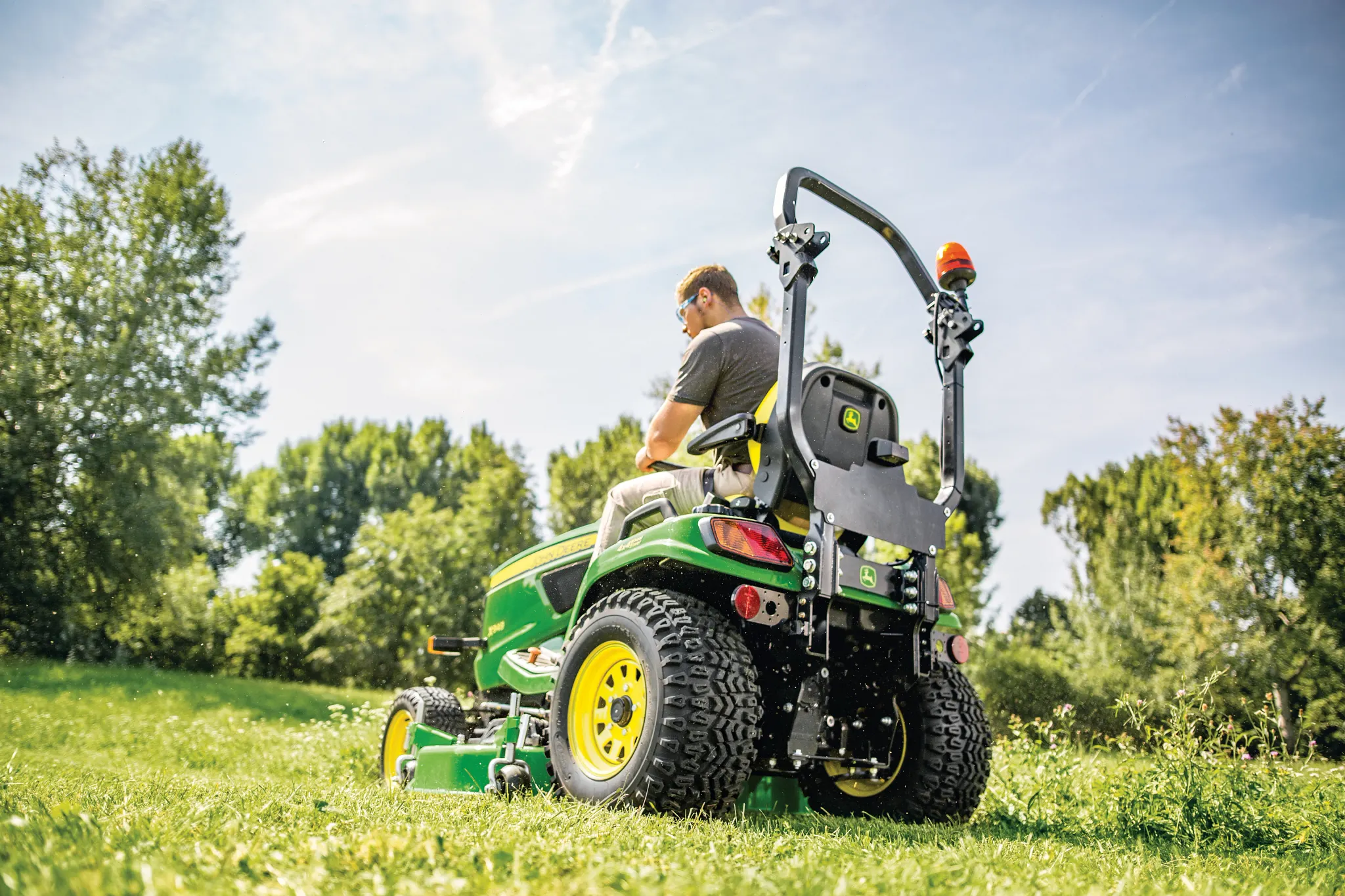 Rear left view of X900 Series lawn tractor in the field