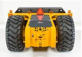 Rear view of a yellow ejector scraper with two large treaded tires, a central control panel, and a red triangular slow‑moving‑vehicle emblem