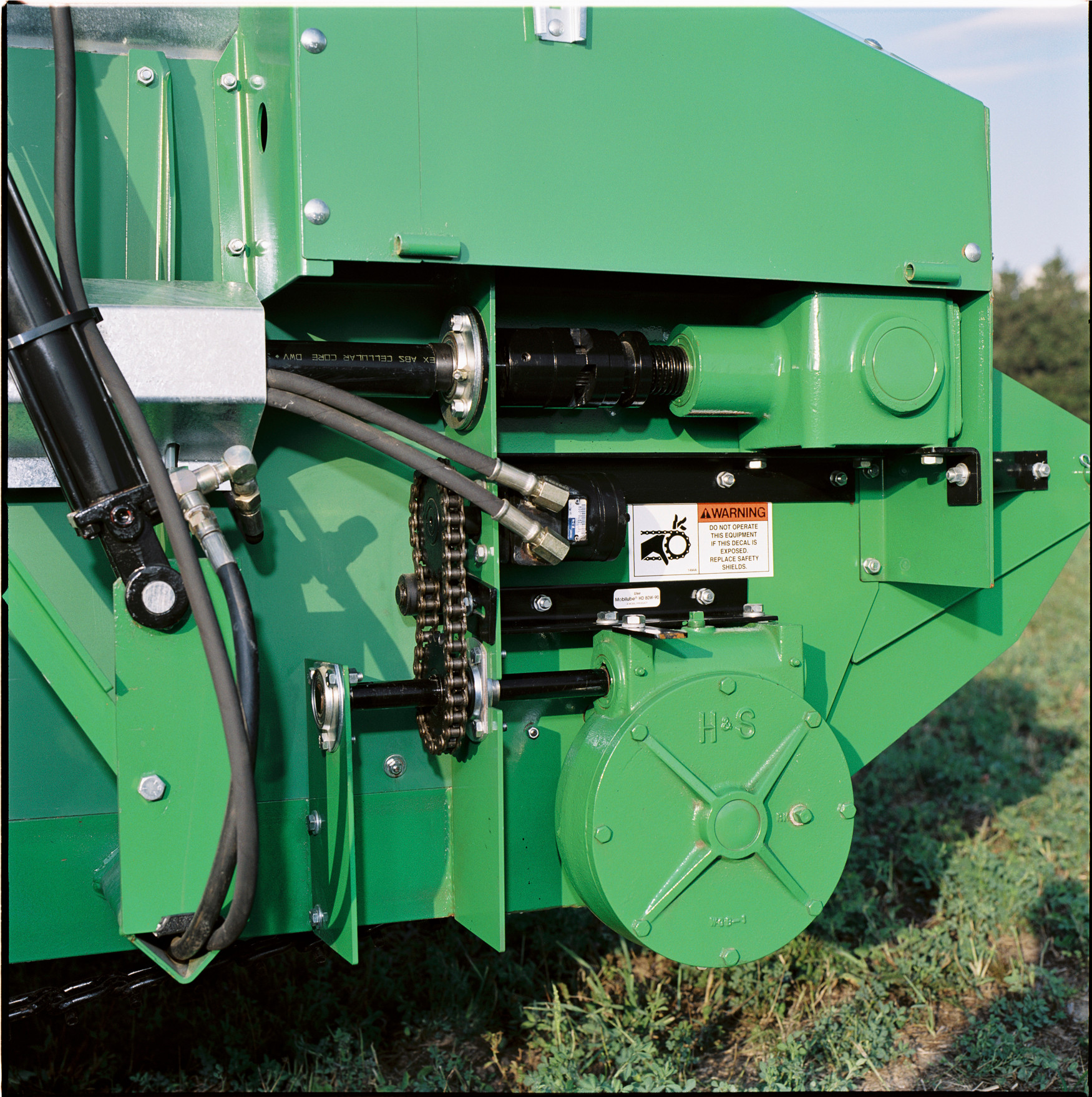 Side view of the apron drive on a manure spreader sitting in a field