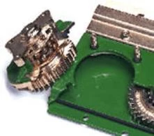Studio close-up of an R-series disc mower's removed gold-and-green disc quill resting on its housing