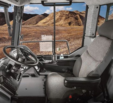 Side view of the interior of an articulated dump truck's Deere-design pressurized cab, featuring adaptive suspension