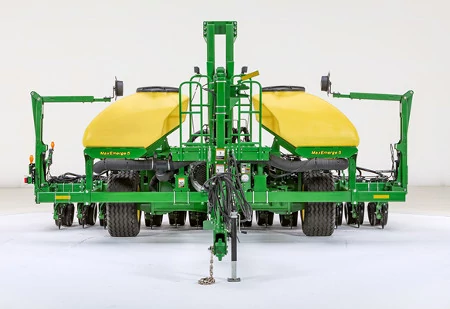 Front view of a John Deere planter with dual yellow seed tanks and green frame, positioned against a plain white background