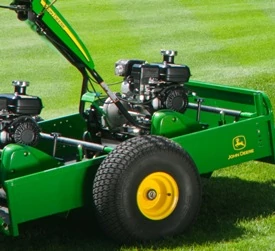 Close-up side view of a 22B walk greens mower trailer with loaded mower sitting on grass