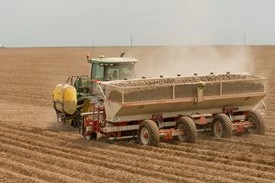 Tractor and potato planter in a dusty field using Active Implement Guidance (AIG)