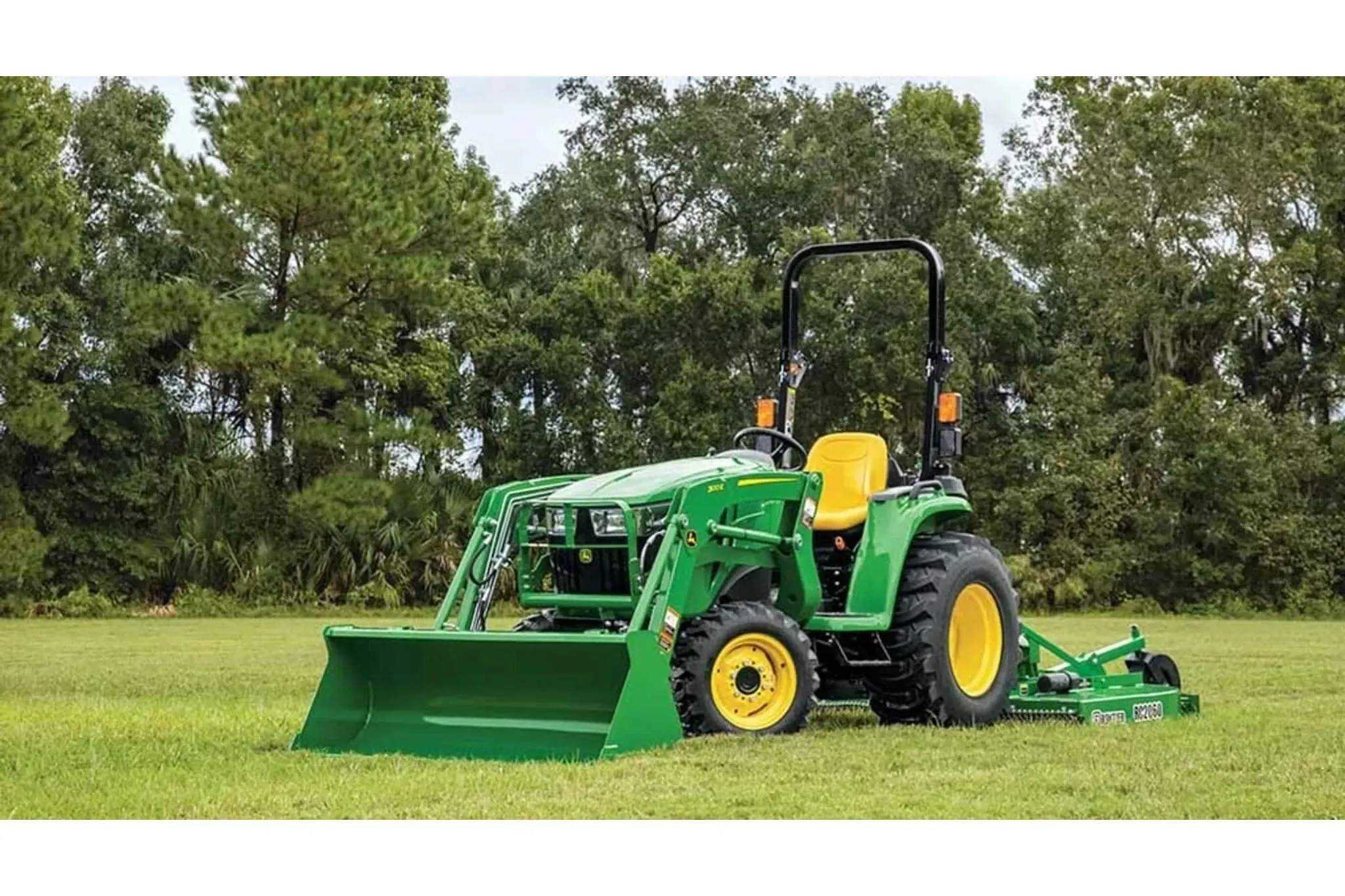 3025E 3 Series Compact Tractors with a green tractor with a plow attachment in a field