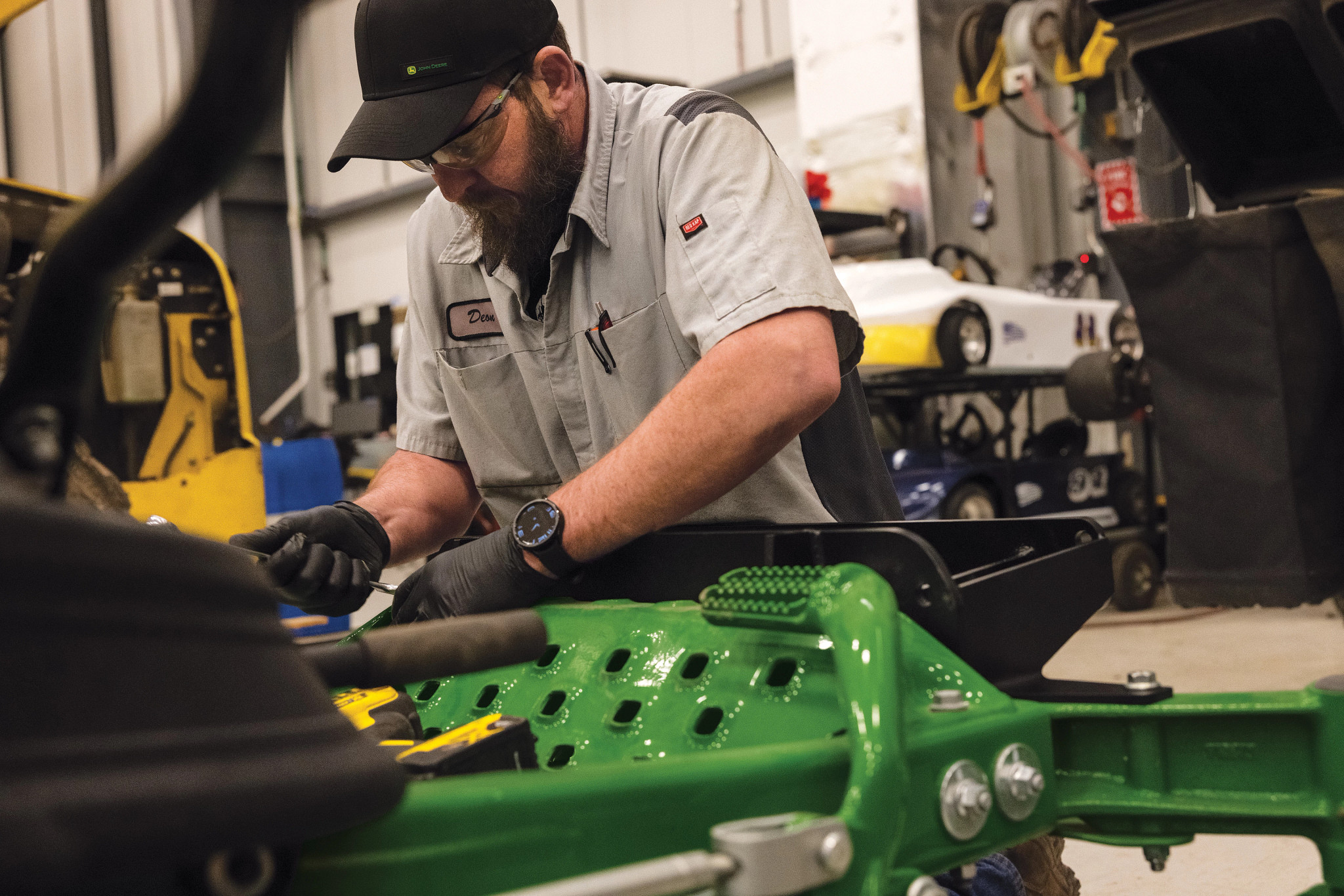 Technician servicing a John Deere lawn mower