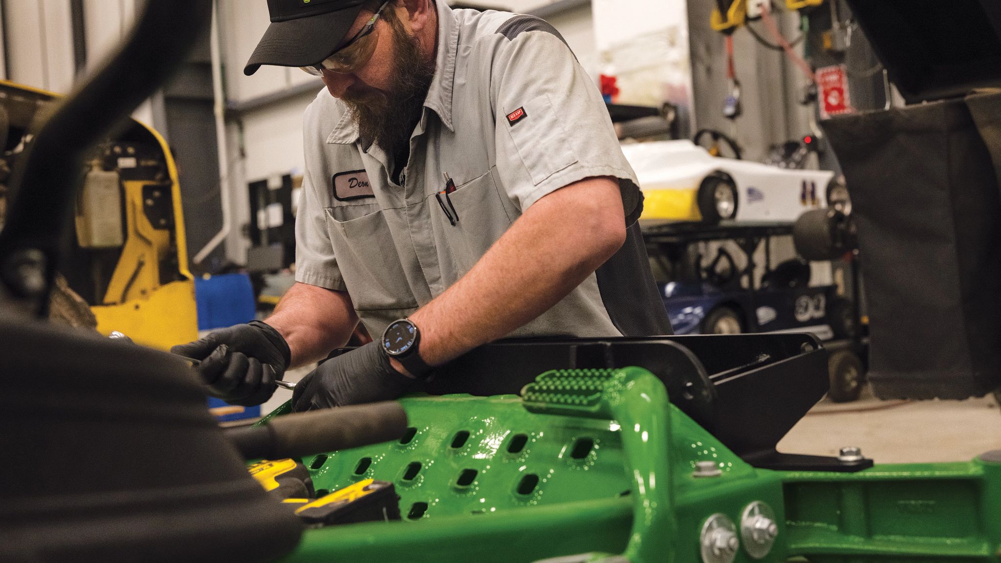 Technician servicing a John Deere mower